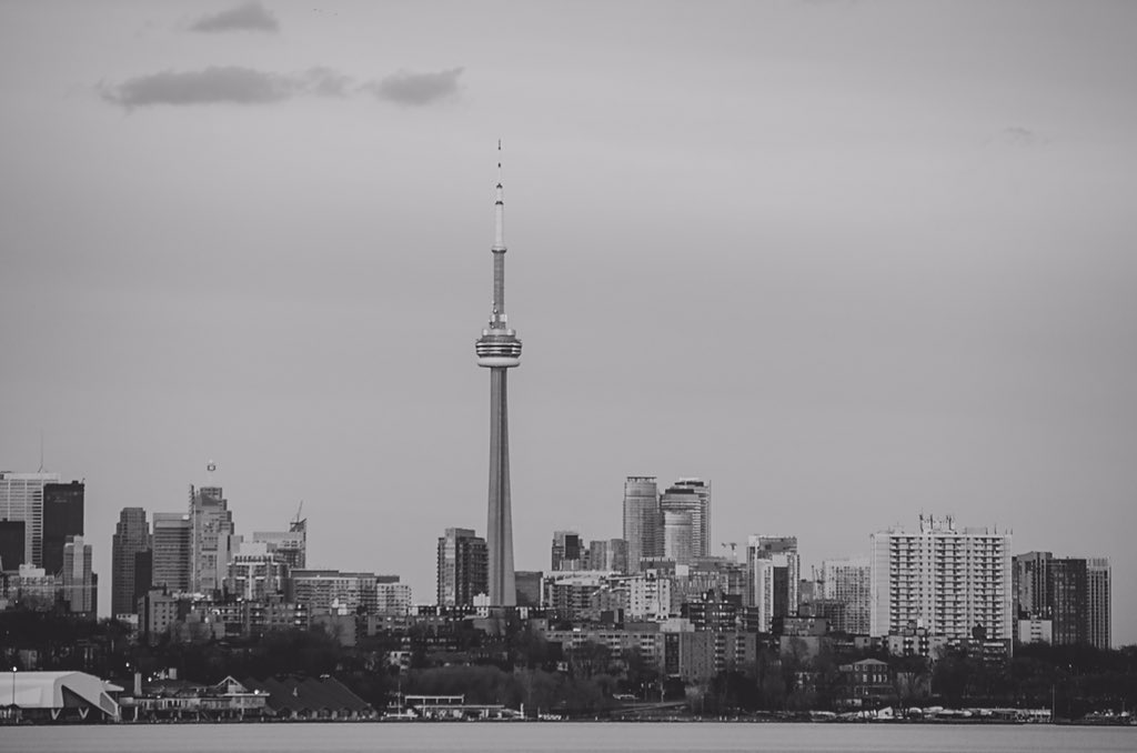 Black and white landscape of Toronto’s skyline, prominently featuring the iconic CN Tower against a minimalist city horizon.