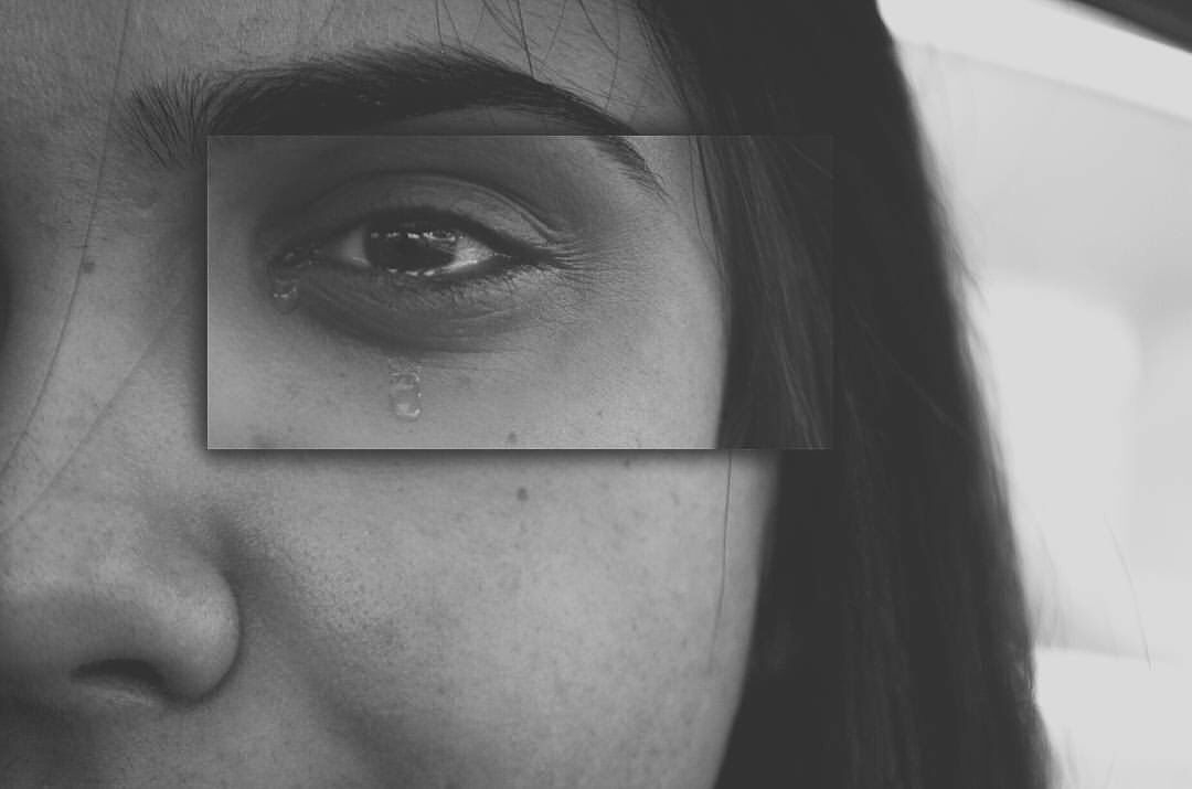 Dramatic black and white extreme close-up of a woman’s face, capturing a single tear rolling down her cheek—evoking emotion and vulnerability.